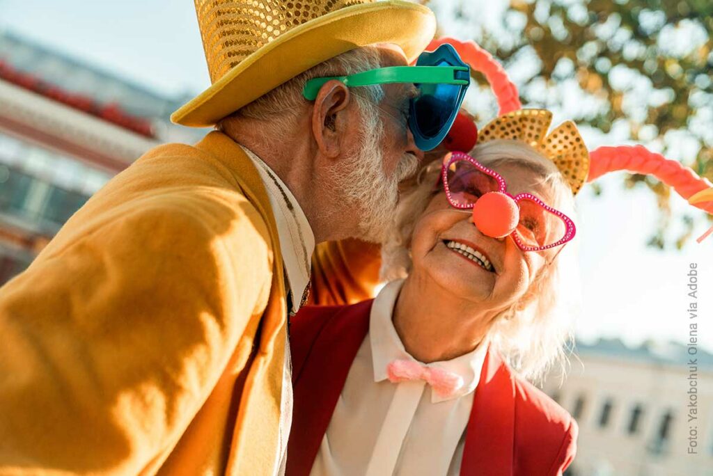 Zahnersatz schenkt Lebensfreue bis ins hohe Alter. Das Foto zeigt ein fröhliches, älteres Paar im Kostüm. Zahnarztpraxis Dr. Fleischer, dein Zahnarzt mit Herz in Dortmund, Foto: Yakobchuk Olena via Adobe
